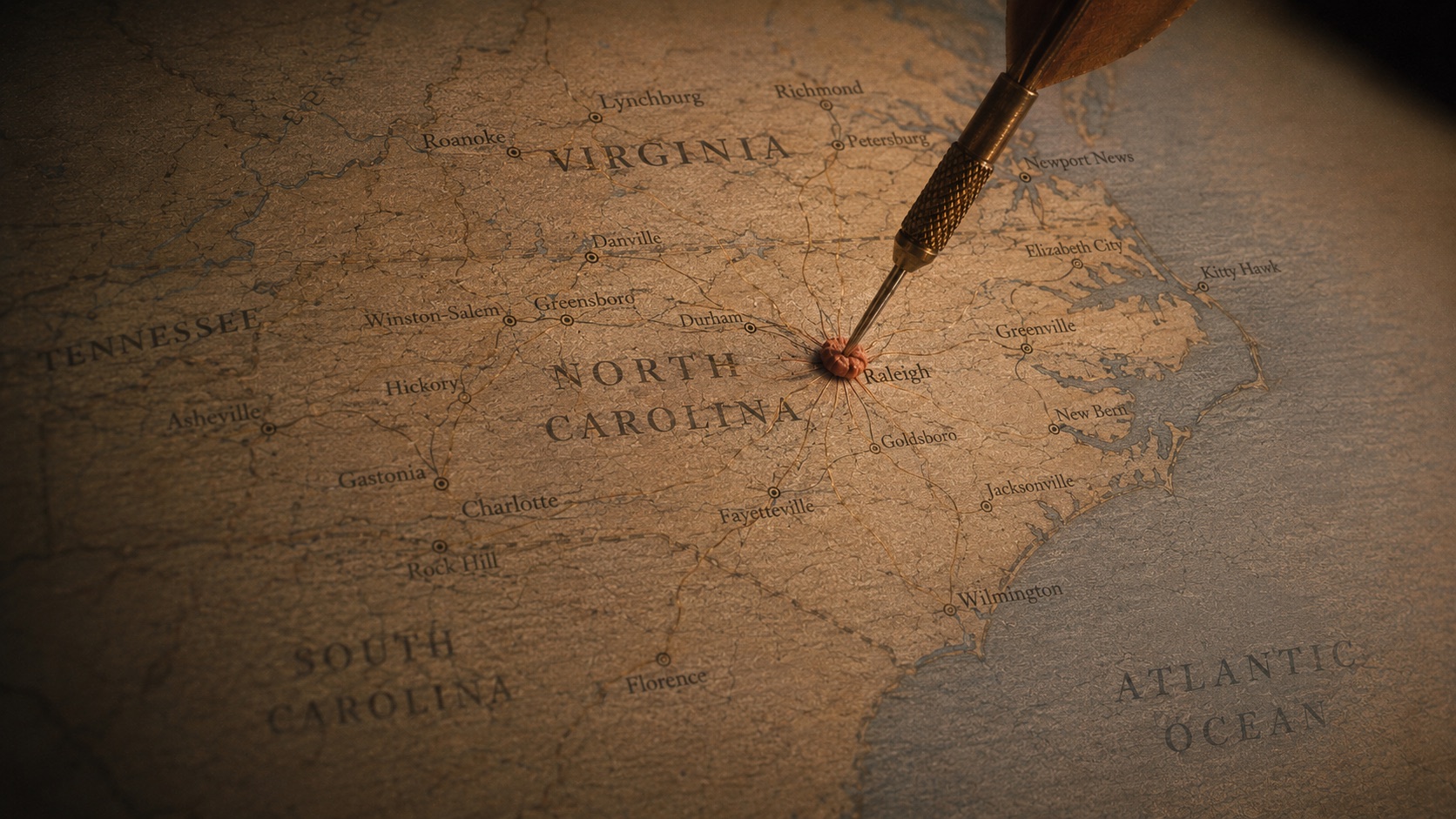 Vintage map of North Carolina with a dart landing on Charlotte